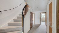 Zuhause zwischen Natur und Stadt – großzügig wohnen mit Komfort - Flur mit Zugang zum Obergeschoss